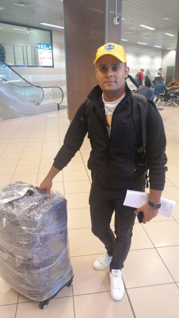muncitor din Bangladesh in aeroport cu bagaj